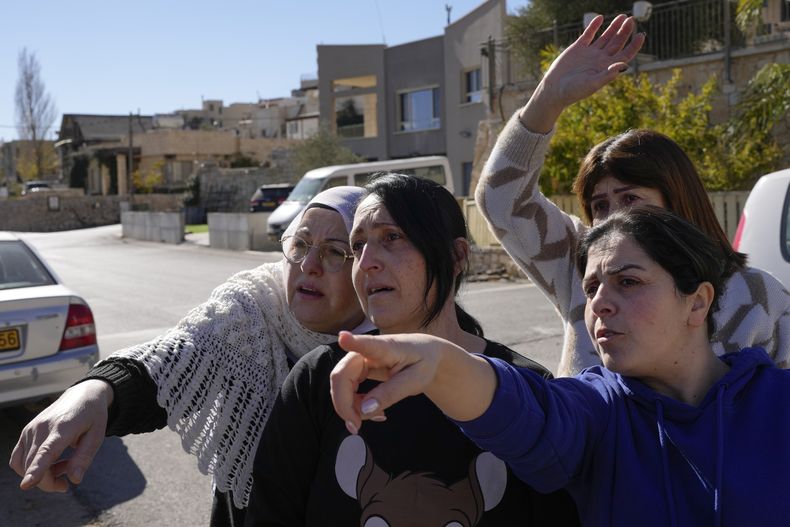 Soja Safadi, en el centro, con sus hermanas, intenta ver a su otra hermana, Sawsan, que se encuentra dentro de la zona de contención cerca de la Línea Alfa que separa los Altos del Golán controlados por Israel de Siria, en la localidad de Majdal Shams, miércoles 18 de diciembre de 2024. (AP foto/Matias Delacroix)