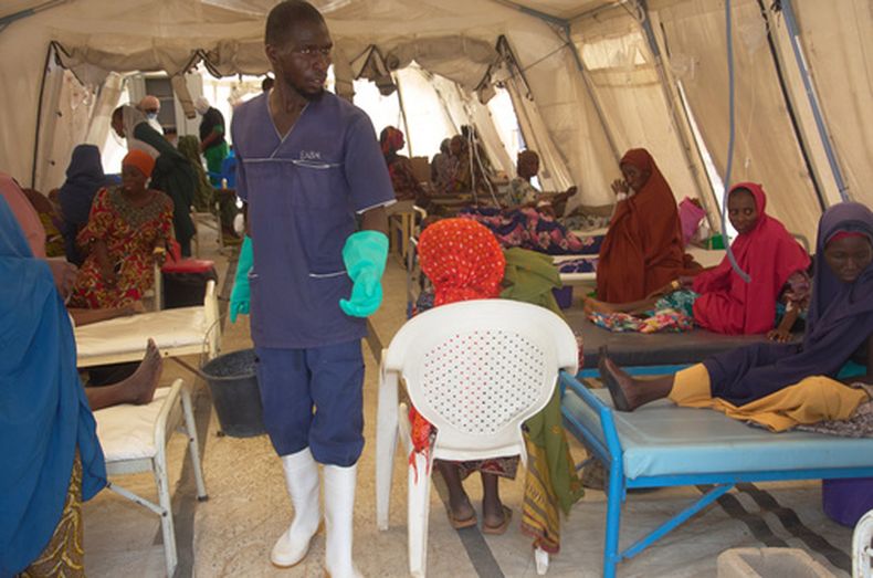 Un trabajador pasa junto a pacientes que reciben tratamiento contra el cólera en el centro de tratamiento de Médicos Sin Fronteras, el lunes 8 de junio de 2026, en Maiduguri, Nigeria. (AP Foto/Jude Mike)