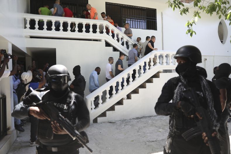Colombianos y haitianos acusados de participar en el asesinato en 2021 del presidente de Haití, Jovenel Moise, son escoltados esposados a su vista judicial en Puerto Príncipe, Haití, el lunes 26 de mayo de 2025. (AP Foto/Odelyn Joseph)