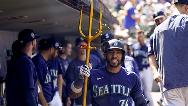 José Caballero, de los Marineros de Seattle, sostiene un tridente en la banca después de batear un cuadrangular en contra de los Nacionales de Washington durante la octava entrada del juego de béisbol, el miércoles 28 de junio de 2023, en Seattle. (AP Foto/Lindsey Wasson)