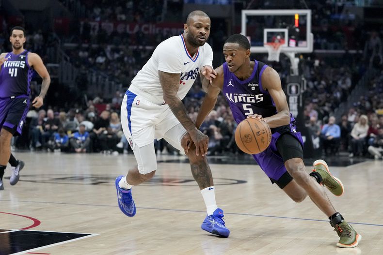 El jugador de los Kings de Sacramento DeAaron Fox, a la derecha, elude al jugador de los Clippers de Los Ángeles P.J. Tucker durante la primera mitad de su juego de NBA el domingo 25 de febrero de 2024 en Los Ángeles. (AP Foto/Ryan Sun)
