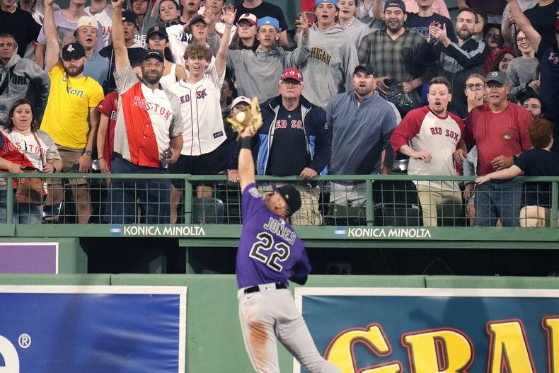 Aficionados reacciona a la atrapada del jardinero derecho de los Rockies de Colorado Nolan Jones tras el batazo de Rafael Devers de los Medias Rojas de Boston en la octava entrada del juego del lunes 12 de junio del 2023. (AP Foto/Charles Krupa)