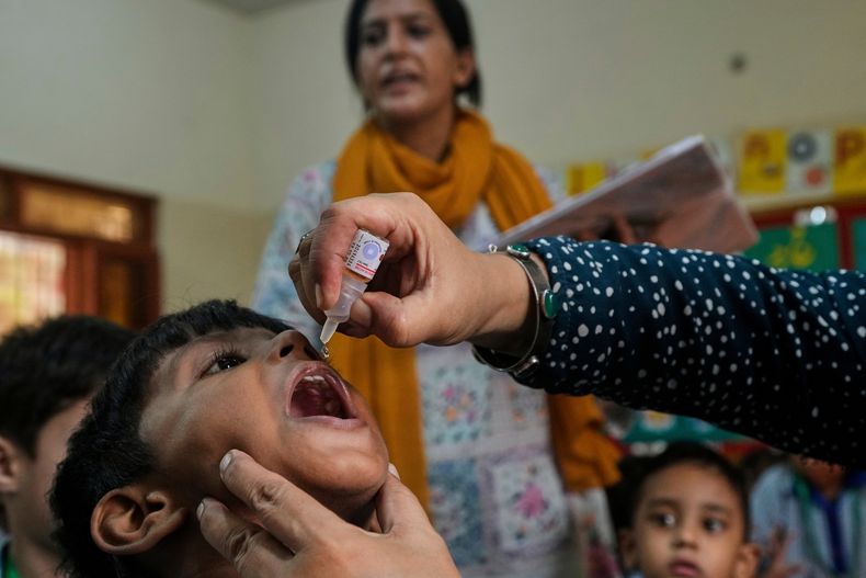 Una trabajadora de salud administra una vacuna contra la polio a un niño en una escuela en Karachi, Pakistán, el lunes 1 de septiembre de 2025. (AP Foto/Fareed Khan)