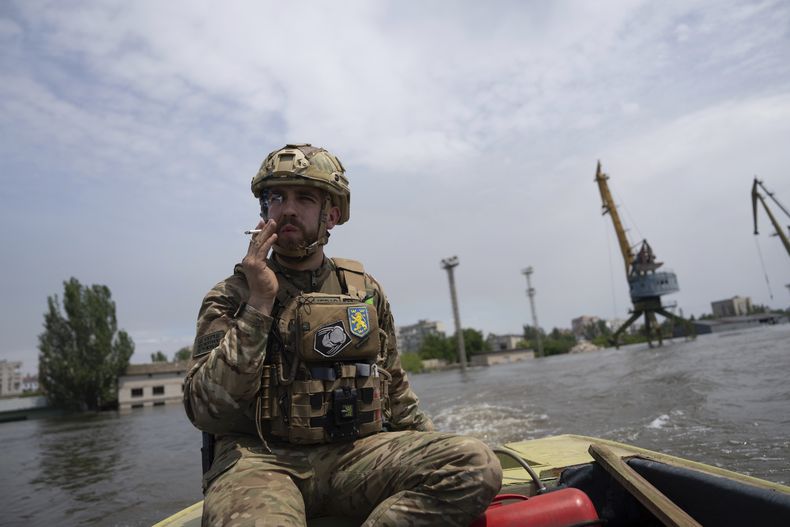 Un soldado ucraniano conduce un bote en un vecindario inundado el jueves 8 de junio de 2023, en Jersón, Ucrania. (AP Foto/Evgeniy Maloletka, archivo)
