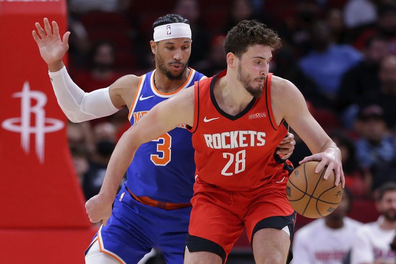 Josh Hart (3), de los Knicks de Nueva York, presiona a Alperen Sengun (28), de los Rockets de Houston, quien busca girar rumbo a la canasta durante la primera mitad del juego de baloncesto de la NBA, el lunes 4 de noviembre de 2024, en Houston. (AP Foto/Michael Wyke)