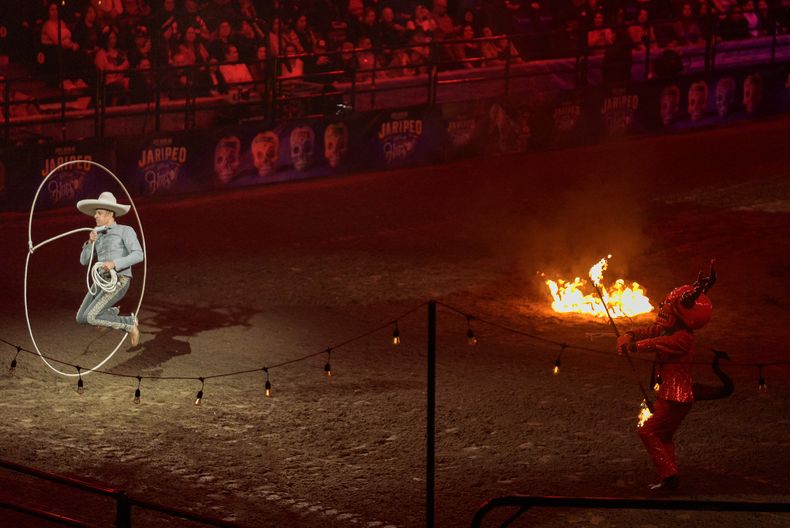 Luis Miguel Rivera hace trucos con un lazo el espectáculo Jaripeo hasta los huesos tour 2024 de Pepe Aguilar en el Honda Center en Anaheim, California, el viernes 29 de marzo de 2024. El espectáculo rinde homenaje al Día de Muertos, una conocida celebración mexicana. (Foto AP/Damian Dovarganes)