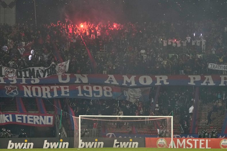 Hinchas de Independiente Medellín encienden bengalas como parte de una protesta que forzó la cancelación del partido de la Copa Libertadores ante Flamengo, el jueves 7 de mayo de 2026 (AP Foto/Fernando Vergara)