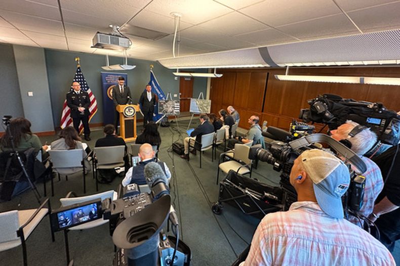 En esta imagen tomada con un smartphone, Mike Herrington, agente especial a cargo del FBI, durante una conferencia de prensa, el martes 6 de octubre de 2026, en Seattle. Está acompañado por el subcomisionado de la Real Policía Montada de Columbia Británica, Elija Rain, a la izquierda, y el subsecretario de justicia interino de Estados Unidos, Neil Floyd. (AP Foto/Manuel Valdes)