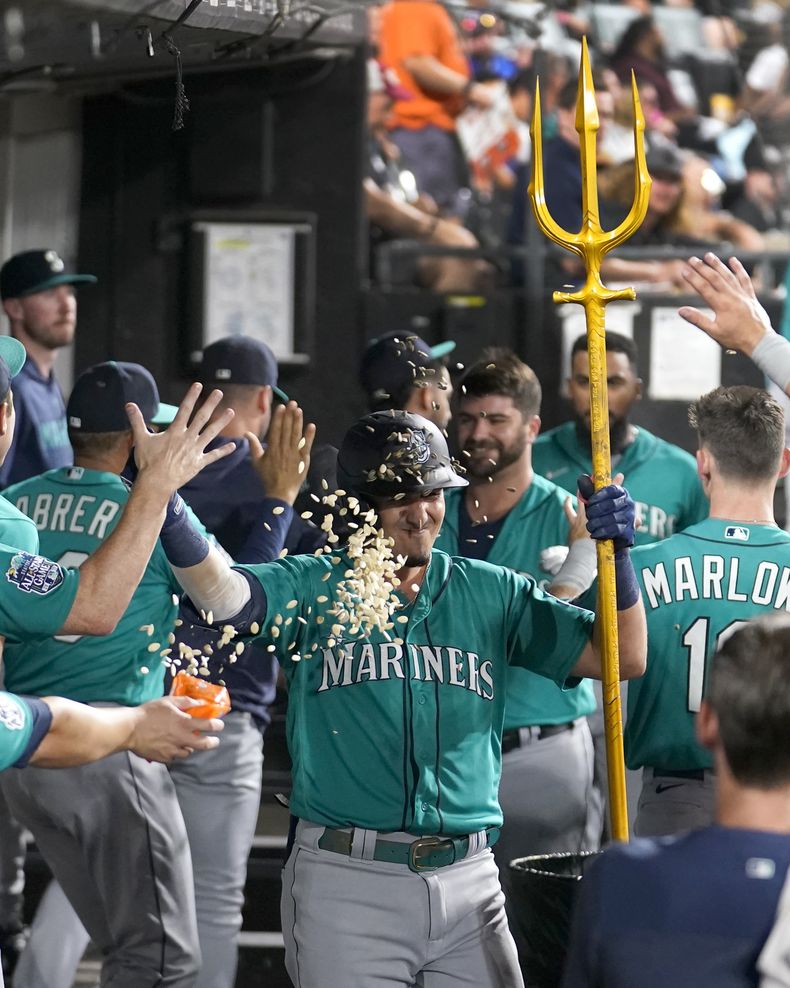 Josh Rojas, de los Marineros de Seattle, festeja en la cueva luego de conseguir un jonrón en el encuentro del martes 22 de agosto de 2023 (AP Foto/Charles Rex Arbogast)