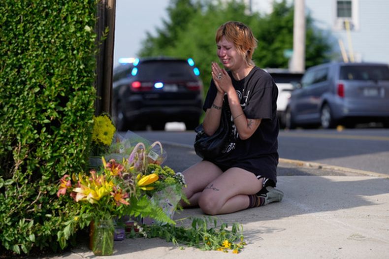 Una mujer ora tras deja flores cerca del sitio donde un hombre fue abatido a tiros por agentes del Servicio de Inmigración y Control de Aduanas de Estados Unidos (ICE, por sus siglas en inglés) el lunes 13 de julio de 2026, en Biddeford, Maine. (AP Foto/Robert F. Bukaty)