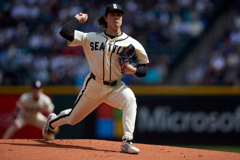 El lanzador abridor de los Marineros de Seattle, Bryan Woo, lanza contra los Rangers de Texas durante la primera entrada de un juego de béisbol el domingo 19 de abril de 2026, en Seattle. (AP Foto/John Froschauer)