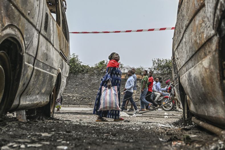 Residentes caminan al lado de vehículos calcinados en Goma, República Democrática del Congo, el 31 de enero del 2025. (AP foto/Moses Sawasawa)