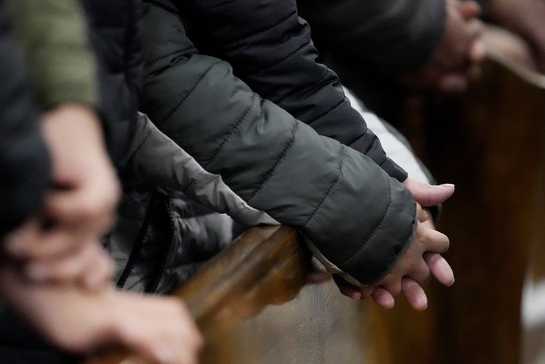 Feligreses se toman de las manos durante una misa en la Parroquia de Santa Rita de Cascia, el domingo 19 de enero de 2025, en Chicago. (AP Foto/Nam Y. Huh)