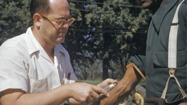 En esta foto de archivo de 1950 publicada por los Archivos Nacionales, un médico extrae sangre a un hombre afroestadounidense al que se incluyó en un estudio sobre la sífilis en Tuskegee, Alabama. (National Archives via AP)