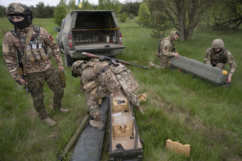 Los miembros de una unidad de defensa aérea ucraniana hacen una exhibición de su labor cerca de Kiev el lunes 8 de mayo de 2023. Desde posiciones camufladas, las unidades se lanzan en camiones a los campos agrícolas alrededor de la capital, listas para derribar drones o misiles enemigos. Desde que Rusia reanudó los ataques aéreos regulares el 28 de abril, las unidades tienen un puntaje perfecto, interceptando cada disparo de drones y misiles contra la capital. (AP Foto/Andrés Kravchenko)