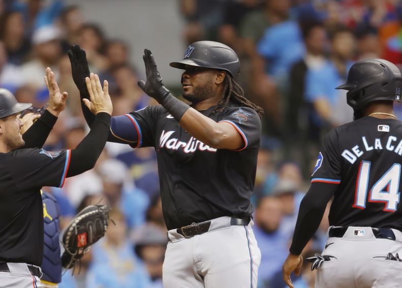 Josh Bell, de los Marlins de Miami, es felicitado por Nick Fortes tras batear un jonrón de tres carreras ante los Cerveceros de Milwaukee, el sábado 27 de julio de 2024 (AP Foto/Jeffrey Phelps)