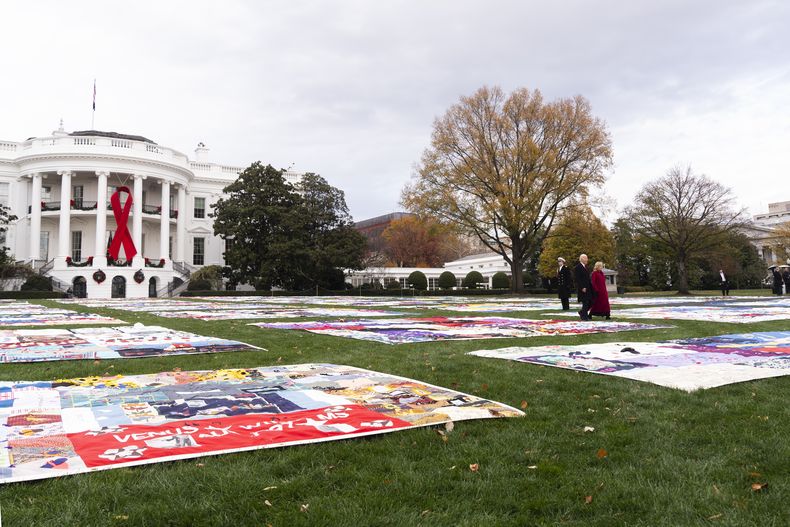 El presidente Joe Biden y la primera dama Jill Biden caminan hacia edredones para conmemorar el Día Mundial de la Lucha contra el Sida, el domingo 1 de diciembre de 2024, en Washington. (AP Foto/Manuel Balce Ceneta)