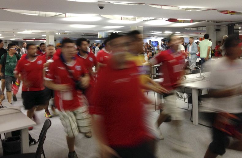 Un grupo de hinchas chilenos irrumpe en el centro de prensa del estadio Maracan&aacute;, antes del partido del Grupo B mundialista entre la seleccion de su pais y Espa&ntilde;a, el mi&eacute;rcoles 18 de junio de 2014 (AP Foto/Akmal Rajput)