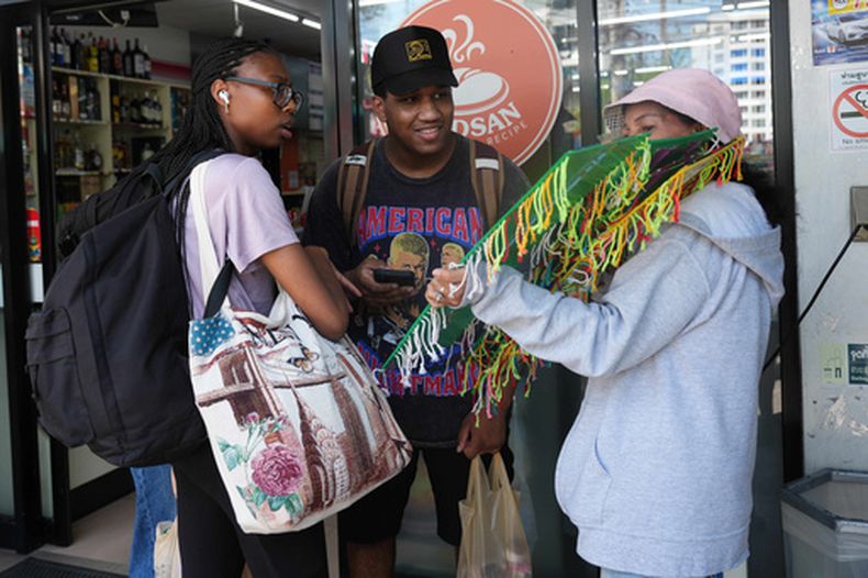 Miembros de la tripulación del USS Abraham Lincoln hablan con una vendedora de recuerdos en Pattaya, Tailandia, el 3 de septiembre de 2026. (AP Foto/Sakchai Lalit)