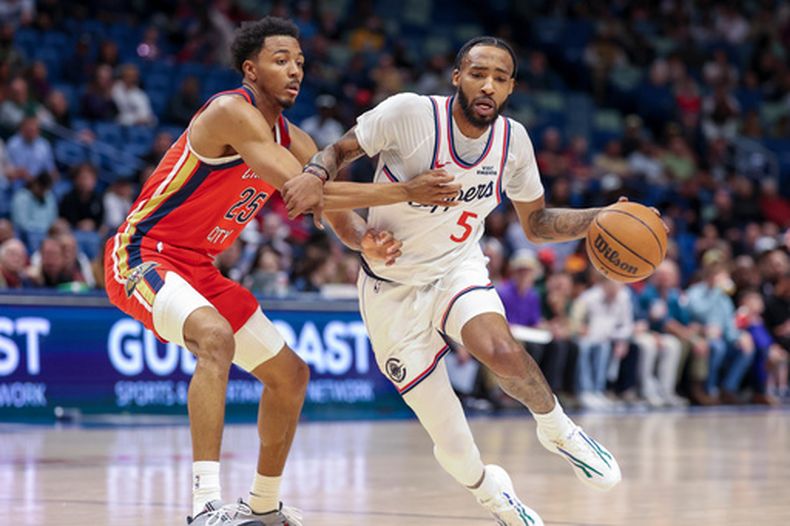 El alero de los Clippers de Los Ángeles, Derrick Jones Jr. (5), intenta penetrar ante la marca del alero de los Pelicans de Nueva Orleans, Trey Murphy III (25), en la primera mitad de un juego de baloncesto de la NBA en Nueva Orleans, el jueves 19 de marzo de 2026. (Foto AP/Peter Forest)