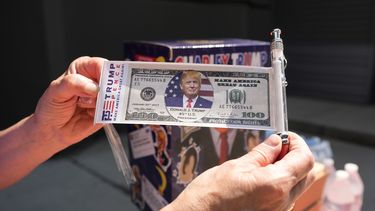 Una persona muestra un billete con la imagen del expresidente Donald Trump el sábado 22 de junio de 2024, antes de un mitin afuera de la Universidad Temple de Filadelfia. (Foto AP/Chris Szagola)