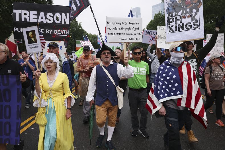 Manifestantes con atuendos de la época de la Guerra de Independencia de Estados Unidos marchan por Benjamin Franklin Parkway en la protesta No Kings (“Sin reyes”) el sábado 14 de junio de 2025, en Filadelfia. (AP Foto/Yuki Iwamura)