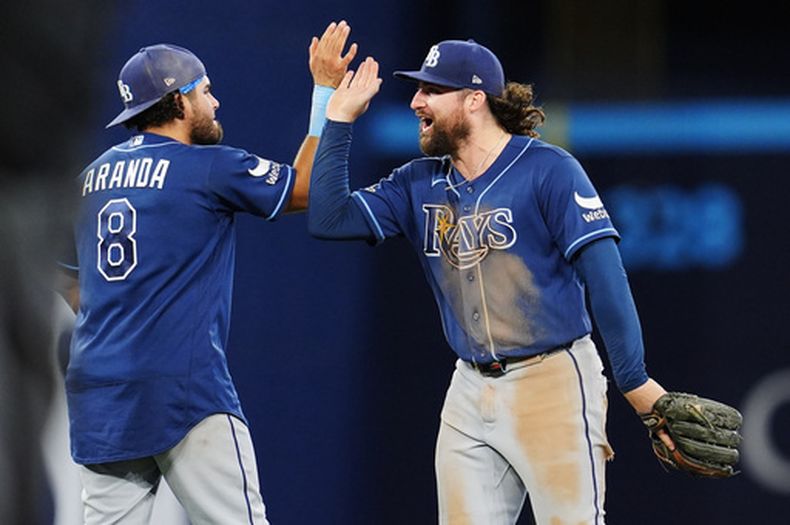 Jonathan Aranda (8) y Ryan Vilade (26), de los Rays de Tampa Bay, celebran tras derrotar a los Azulejos de Toronto en una jornada de béisbol de las Grandes Ligas en Toronto, el martes 12 de mayo de 2026. (Frank Gunn/The Canadian Press vía AP)