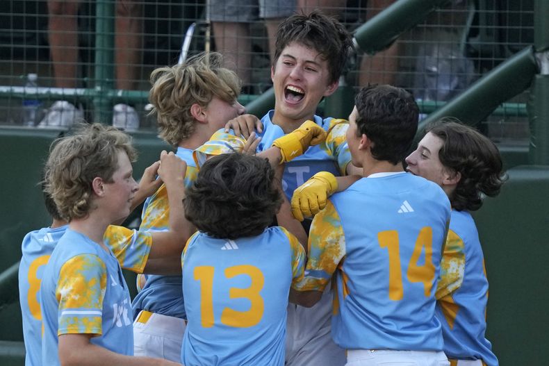 Louis Lappe, centro, de El Segundo, California, celebra con sus compañeros de equipo después de batear un cuadrangular con el que su equipo dejó tendido a Curazao durante la sexta entrada en la Serie Mundial de Pequeñas Ligas, en South Williamsport, Pennsylvania, el domingo 27 de agosto de 2023. California ganó 6-5. (AP Foto/Gene J. Puskar)