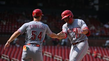 Sal Stewart de los Rojos de Cincinnati celebra con el coach de primera base Collin Cowgill su sencillo remolcador en la décima entrada ante los Cardenales de San Luis el domingo 26 de julio del 2026. (AP Foto/Jeff Le)