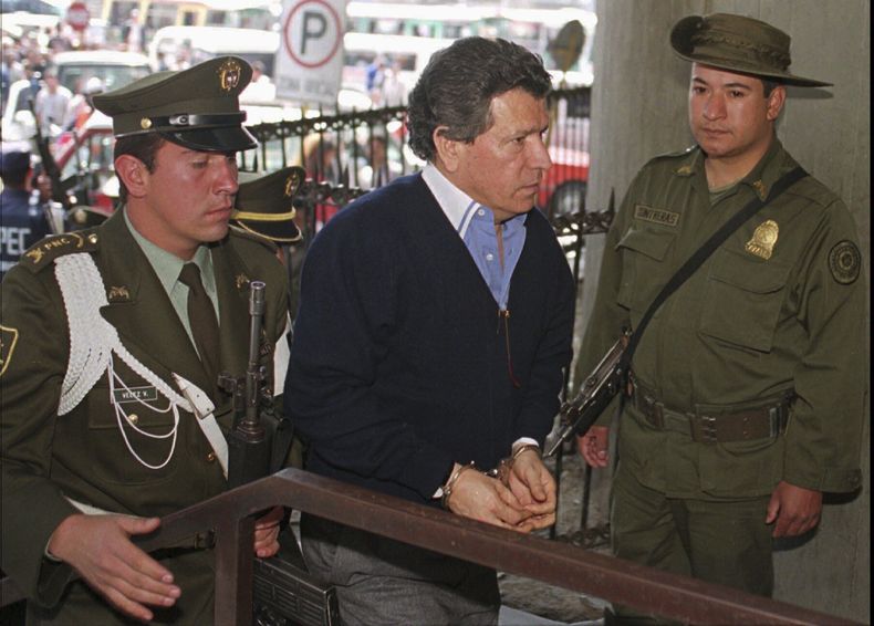 ARCHIVO - Miguel Rodríguez Orejuela, un líder del Cártel de Cali, es escoltado por policías colombianos a su entrada a la sede de la Fiscalía General en Bogotá, Colombia, en un foto de archivo de septiembre de 1996. (AP Foto/Fernando Llano, Archivo)
