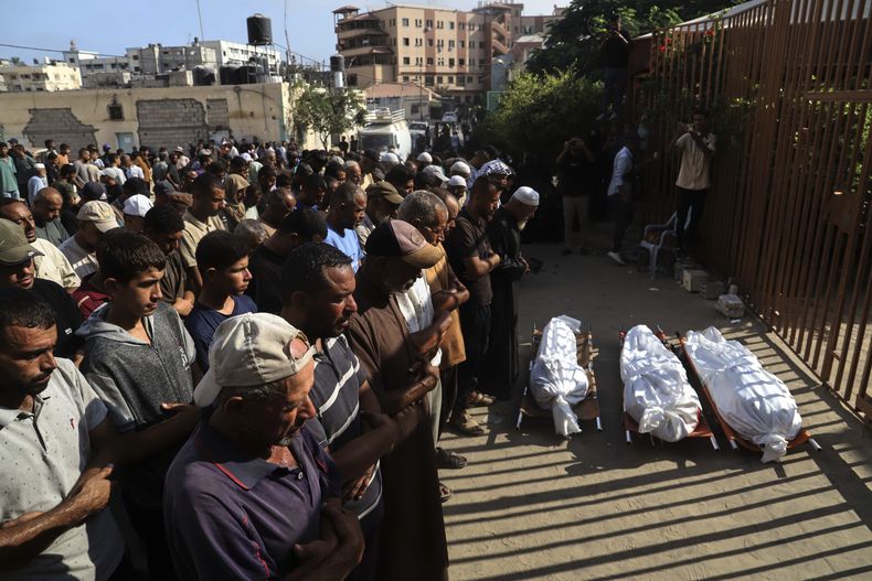 Palestinos despiden los cuerpos de tres víctimas de ataques israelíes, durante su funeral en el exterior del hospital Nasser, en Jan Yunis, en el sur de la Franja de Gaza, el 23 de agosto de 2025. (AP Foto/Mariam Dagga)