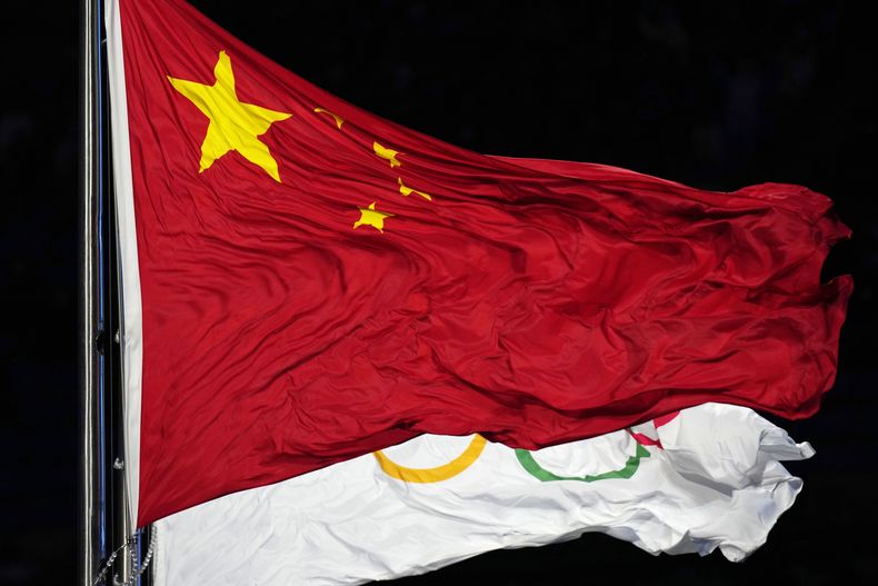 ARCHIVO - Foto del 4 de febrero del 2024, la bandera olímpica y de China ondean durante la ceremonia de apertura de los Juegos Olímpicos de Invierno en Beijing. (AP Foto/Petr David Josek, file)
