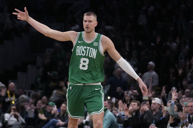 Kristaps Porzingis, pívot de los Celtics de Boston, festeja luego de atinar un triple frente a los Hawks de Atlanta en el duelo del miércoles 7 de febrero de 2024 (AP Foto/Charles Krupa)
