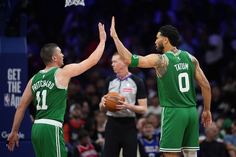 Payton Pritchard, izquierda, y Jayson Tatum (0), de los Celtics de Boston, celebran durante la segunda mitad del cuarto juego de la serie de playoffs de primera ronda del baloncesto de la NBA contra los 76ers de Filadelfia, el domingo 26 de abril de 2026, en Filadelfia. (AP Foto/Matt Slocum)