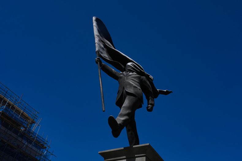 Una estatua de un hombre que sostiene una bandera que le cubre el rostro, firmada como Banksy, apareció en Waterloo Place en Londres el jueves 30 de abril de 2026. (Foto AP/Kin Cheung)