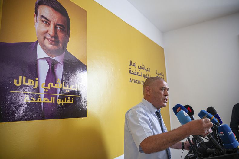 Abdessatar Messaoudi, abogado del candidato tunecino Ayachi Zammel (cuyo retrato se ve en el afiche en la pared), en una conferencia de prensa en Túnez el 16 de septiembre del 2024 (Foto AP /Ons Abid)