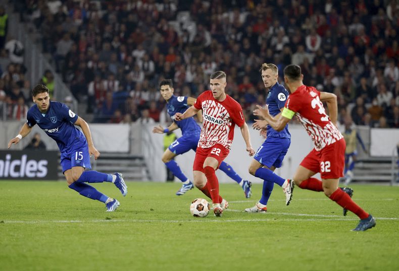 Roland Saillai, de Friburgo, y Konstantinos Mavropanos, de West Ham, disputan un balón en un partido de la Liga Europa, disputado el jueves 5 de octubre de 2023 (Philipp von Ditfurth/dpa via AP)