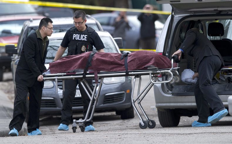 La polic&iacute;a retira un cadaver del lugar donde mataron a pu&ntilde;aladas a cinco personas en el noroeste de Calgary, Alberta, el martes 15 de abril de 2014. (Foto AP/The Canadian Press, Larry MacDougal)
