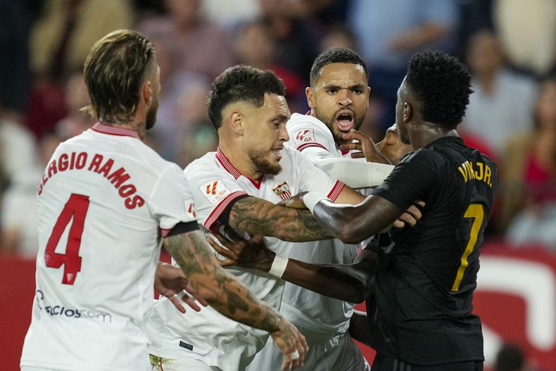 Vinícius Junior, del Real Madrid, discute con algunos jugadores del Sevilla durante un encuentro de La Liga española, realizado el sábado 21 de octubre de 2023 (AP Foto/José Breton)