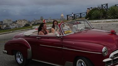Turistas dan un paseo en un auto estadounidense clásico en La Habana, el lunes 26 de enero de 2026. (AP Foto/Ramon Espinosa)