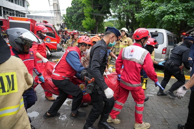 Rescatistas llevan el cuerpo de una víctima del lugar de un incendio en Yakarta, Indonesia, el martes 9 de diciembre de 2025. (AP Foto/Dita Alangkara)