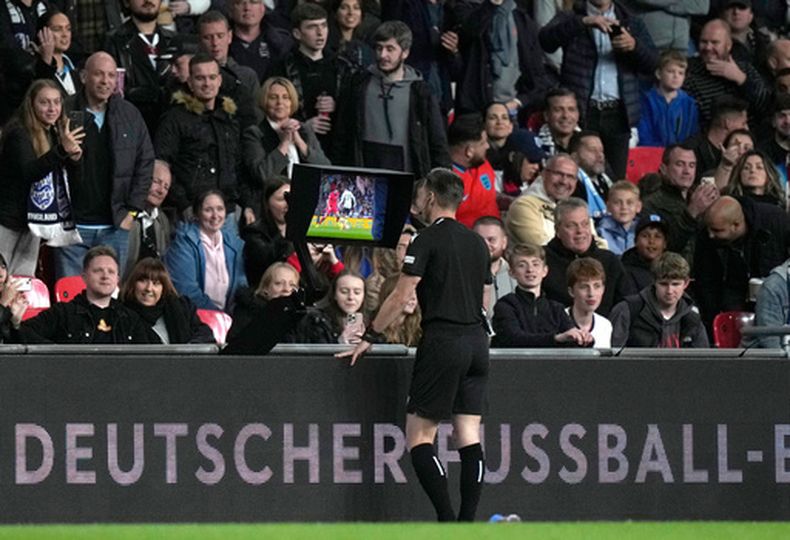 ARCHIVO - El árbitro Danny Desmond Makkelie detiene el partido y solicita el VAR durante el partido de fútbol de la UEFA Nations League entre Inglaterra y Alemania en el Estadio Wembley en Londres, Inglaterra, el lunes 26 de septiembre de 2022. El texto en el panel publicitario dice: German Soccer. (Foto AP/Alastair Grant, archivo)