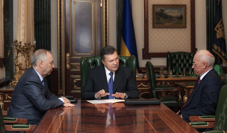 El presidente ucraniano Viktor Yanukovych, centro, dialoga durante una reuni&oacute;n con el primer ministro Mykola Azarov, derecha, y el vocero del parlamento de Ucrania Volodymyr Rybak, izquierda, en Kiev, Ucrania, el lunes 23 de diciembre de 2013. Rusi
