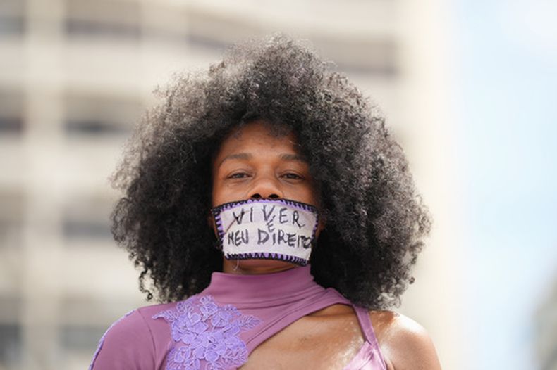 Una mujer con cinta que dice en portugués Vivir es mi derecho sobre la boca participa en la marcha por el Día Internacional de la Mujer en la playa de Copacabana, en Río de Janeiro, el domingo 8 de marzo de 2026. (Foto AP/Silvia Izquierdo)