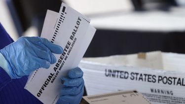ARCHIVO - Un trabajador de la Junta de Empadronamiento y Elecciones del condado de Fulton procesa los votos postales en el State Farm Arena, el 2 de noviembre de 2020, en Atlanta. (Foto AP/John Bazemore, Archivo)