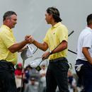 Ryan Fox, de Nueva Zelanda, izquierda, felicita a su compañero Min Woo Lee, de Australia, ambos del Equipo Internacional, mientas Collin Morikawa, de Estados Unidos, derecha, camina en el green del hoyo 18 del torneo de golf Presidents Cup, en la segunda ronda, el viernes 25 de septiembre de 2026, en el Medinah Country Club, en Medinah, Illinois. (AP Foto/Chris Carlson)