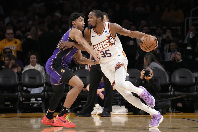 Kevin Durant, alero de los Suns de Phoenix, elude a Max Christie, de los Lakers de Los Ángeles, en el encuentro del jueves 11 de enero de 2024 (AP Foto/Mark J. Terrill)