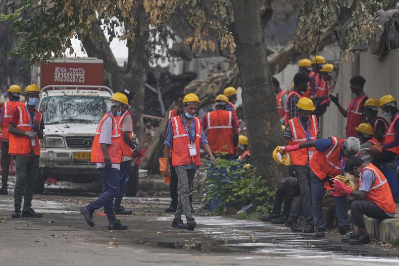 Trabajadores locales descansan cerca del sitio del choque mortal de un avión de Air India plane en Ahmedabad, India, el lunes 16 de junio de 2025. (AP Foto/Rafiq Maqbool)