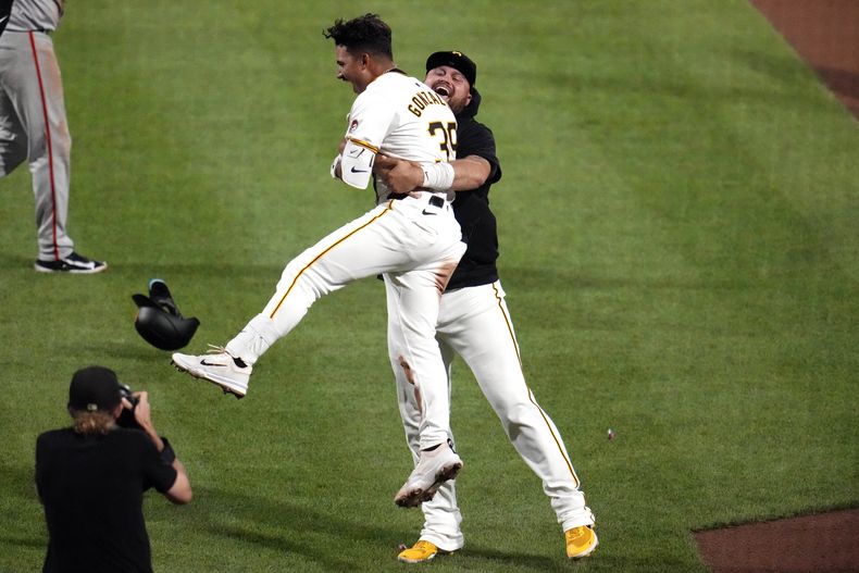 Nick Gonzales, de los Piratas de Pittsburgh, es cargado por el mexicano Rowdy Téllez, para felicitarlo por su sencillo decisivo ante los Gigantes de San Francisco, el martes 21 de mayo de 2024 (AP Foto/Gene J. Puskar)
