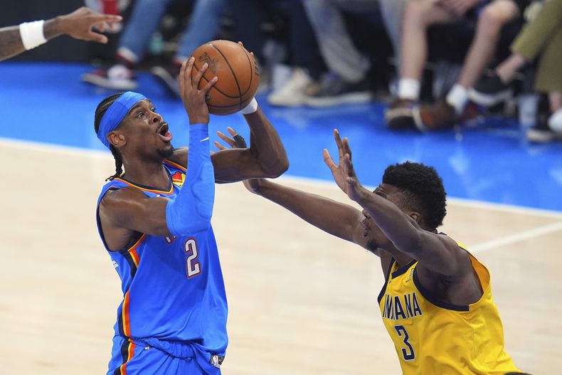 Shai Gilgeous-Alexander (2), del Thunder de Oklahoma City, tira a la canasta con la marca defensiva de Thomas Bryant (3), de los Pacers de Indiana, durante la primera mitad del segundo juego de las Finales de la NBA, el domingo 8 de junio de 2025, en Oklahoma City. (AP Foto/Julio Cortez)